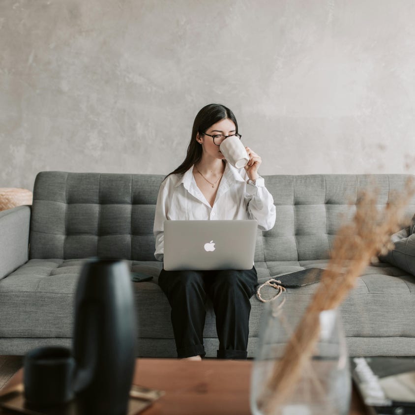 Woman Drinking Coffee While Working With Laptop